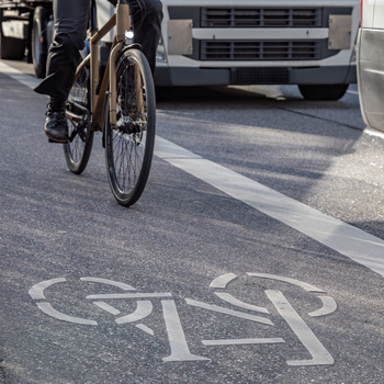 Cycle and lorry on busy route through an urban centre.