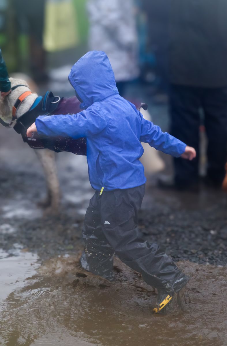 A child jumps through the mud and puddles at Grasmere Lakeland Sports and Show 2024.