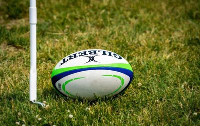 Rugby ball sitting on a rugby field ready for play.