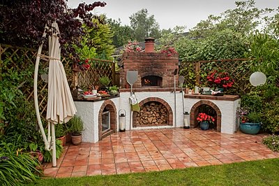 An elaborately designed garden installation housing a Valoriani UK wood fired oven