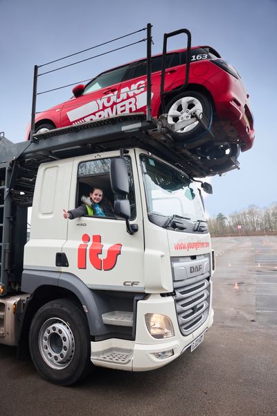 Bonnie (10) in the driver's seat of the delivery truck, bringing the new fleet of Suzuki Swifts to Young Driver