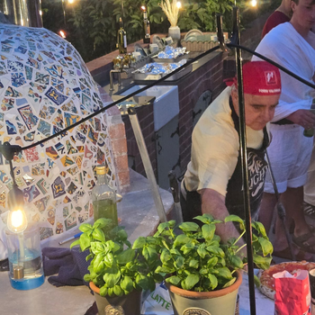 Andrew Manciocchi, owner of Orchard Ovens, cooking for guests at a customer's event, celebrating the 21st birthday of her son.