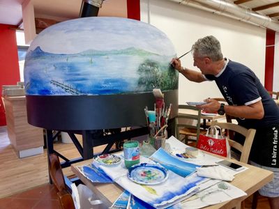A pizza oven being hand painted with a bespoke design,  in the Valoriani factory in Tuscany